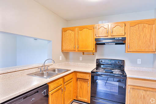 A kitchen with wooden cabinets and a black stove top oven.