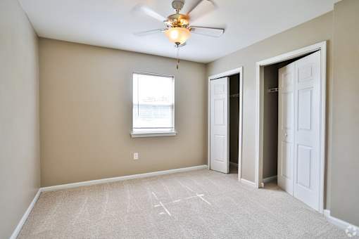 A room with a ceiling fan and a window.