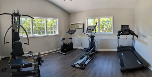 gym with exercise equipment and windows in a room with wood floors