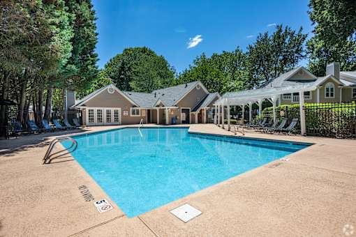 A large swimming pool in front of a house.