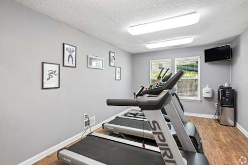 A treadmill with the word "SPIRIT" on it is in a room with a grey wall and a window.