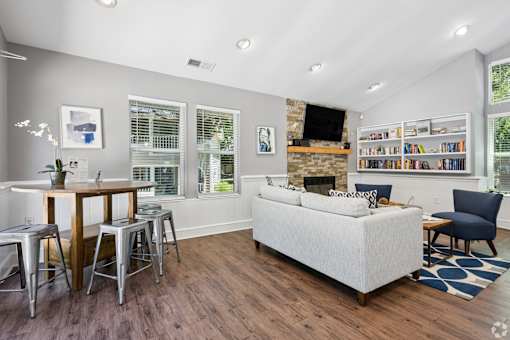 A living room with a white couch, a wooden table, and a fireplace.