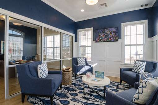 A living room with blue chairs and a white coffee table.