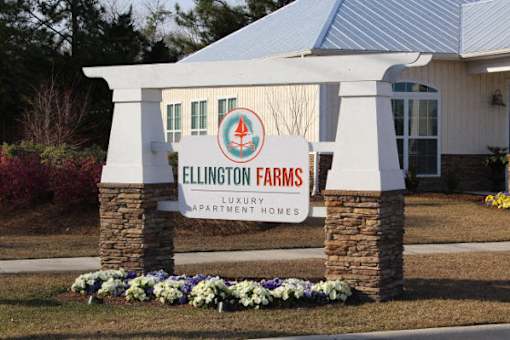 A sign for Ellington Farms in front of a house.