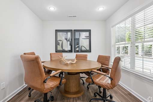 A conference room with a round table and chairs.
