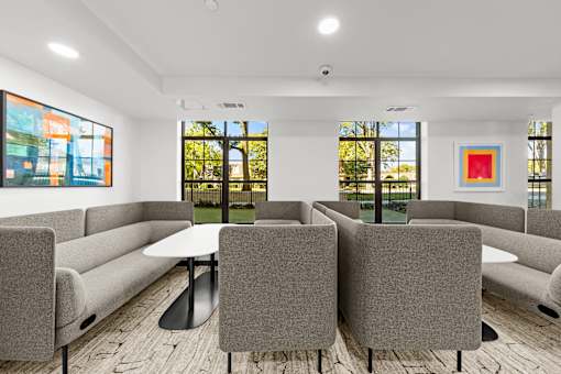 A conference room with a table surrounded by grey chairs.