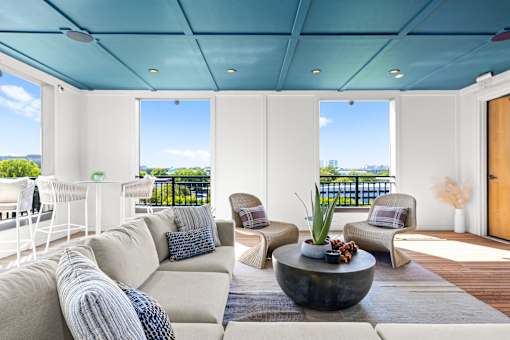 A modern living room with a large sofa and a view of the ocean.