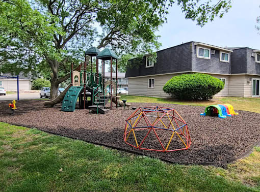 A playground with a swing set, a slide, and a climbing structure.