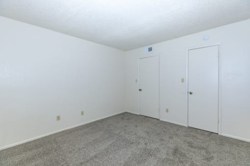 an empty room with carpet and white doors at Tides on Southern, Arizona, 85204