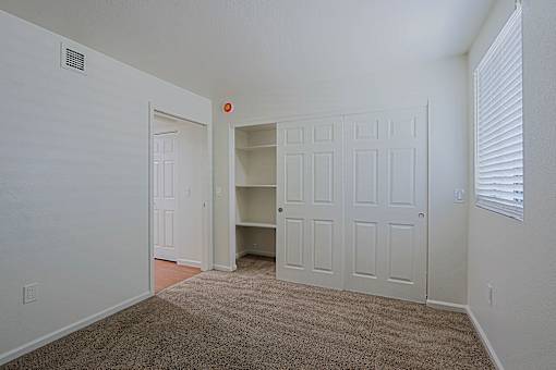 A room with a carpeted floor and a white door.