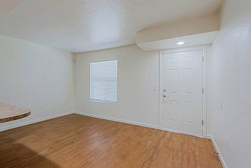 A room with a white door and a window with blinds.