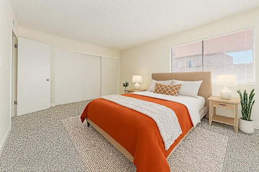 A bedroom with a bed, nightstand, and a plant.