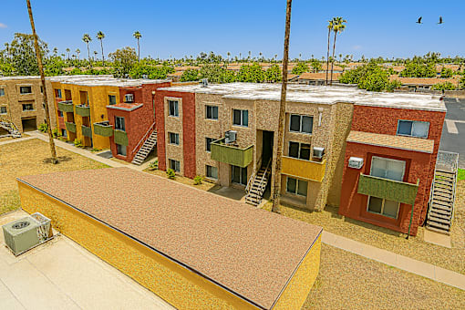 Apartment complex with a red door and a green plant on the window sill.
