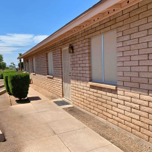 a brick building with two windows and a white door