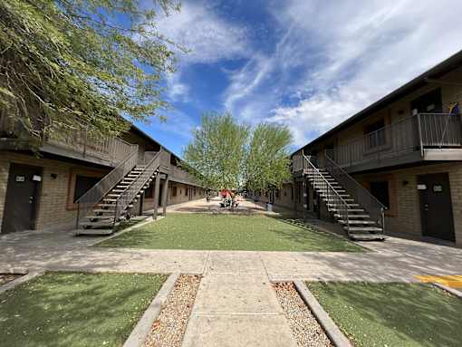 A courtyard surrounded by buildings with a clear blue sky above.