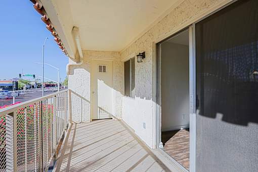 A balcony with a railing and a view of the street below.