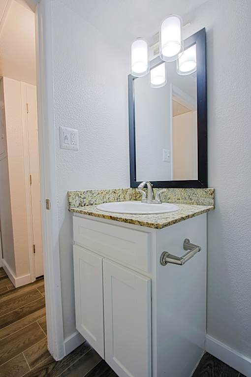A bathroom vanity with a marble top and a mirror above it at Aspire Mesa,  Arizona, 85210.