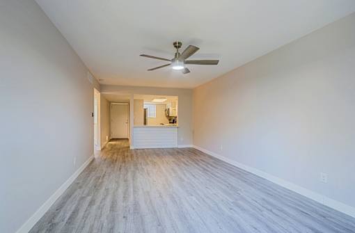 A room with a ceiling fan and light fixture.