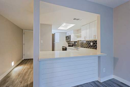 A kitchen with white cabinets and a countertop.