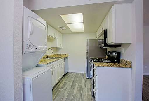 A kitchen with white appliances and cabinets at Aspire Mesa, Mesa.