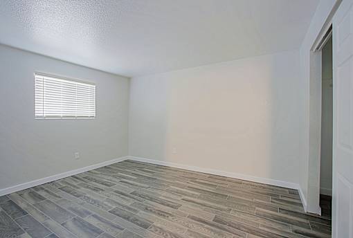 A room with a wooden floor and a window with blinds at Aspire Mesa, Mesa,  Arizona.