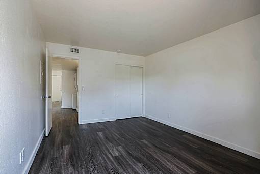 A room with a wooden floor and white walls.