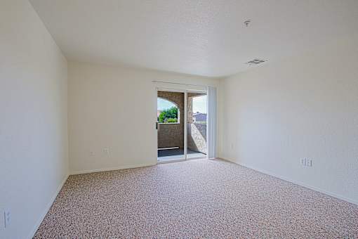 A room with a carpeted floor and a doorway leading to another room.