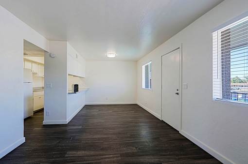 A large empty room with wooden floors and white walls.