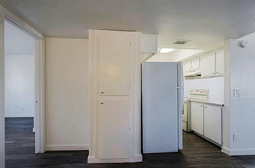 A kitchen with white appliances and cabinets.