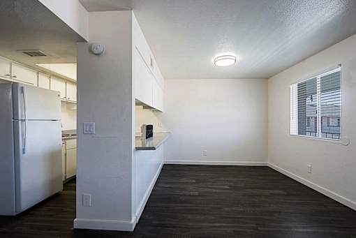 A kitchen with a refrigerator and a countertop with a window.