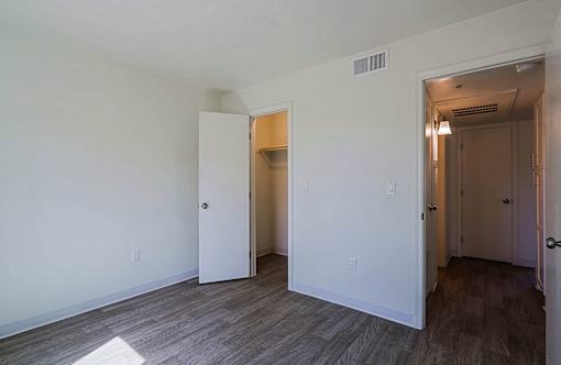 A room with a white wall and a wooden floor.