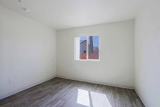 A room with a window and wooden flooring.