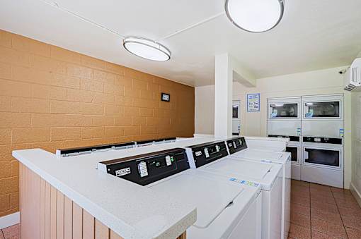 A row of white ovens are lined up in a room.