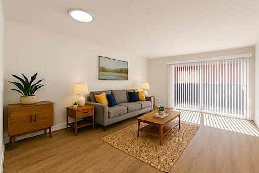 A living room with a grey couch, a wooden coffee table, and a painting on the wall.