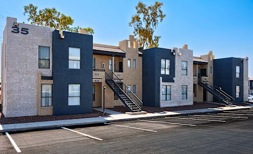 A row of modern townhouses with a clear blue sky above.