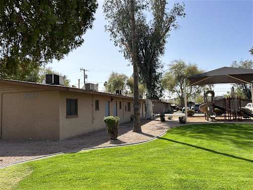 A row of houses with a green lawn in front.