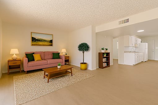 A living room with a pink couch, a small tree, and a painting on the wall.