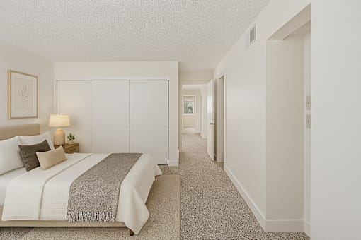 A bedroom with a bed, nightstand, and a lamp.