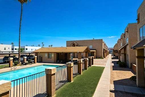 A row of houses with a pool in the foreground.