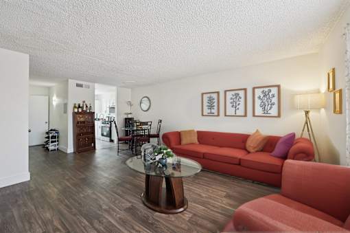 A living room with a red couch and a coffee table.