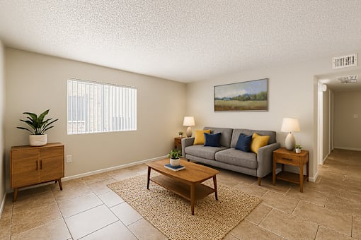 A living room with a grey couch, a wooden coffee table, and a painting on the wall.