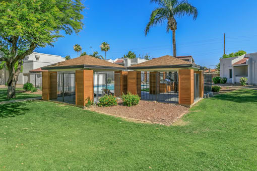 a small house with a gated yard and a palm tree at Tides on Southern, Mesa