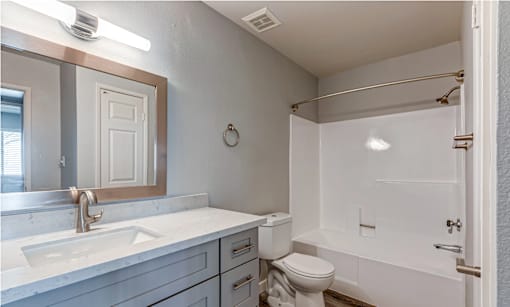 A bathroom with a white toilet, sink, and bathtub.