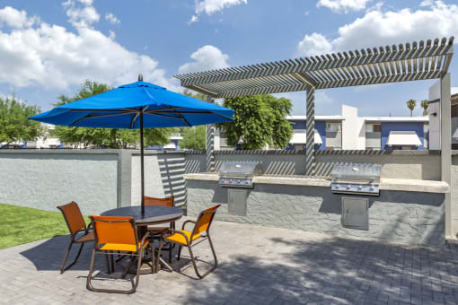 a patio with a table and chairs with an umbrella