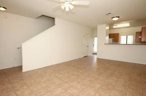Empty room with a ceiling fan and tiled floor.