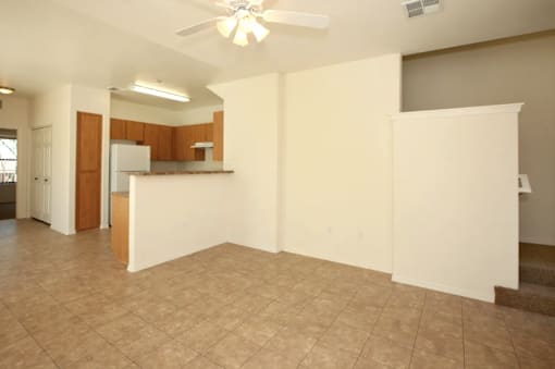 Empty room with a ceiling fan and tiled floor.