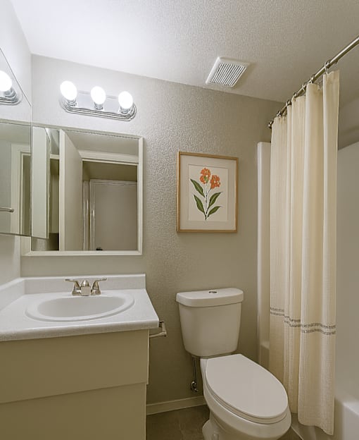 A white toilet sits next to a sink in a bathroom at Connect on Northern, Glendale, AZ 85301
