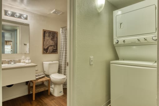 a bathroom with a toilet and a sink and a washer and dryer at Connect on Northern, Arizona, 85301