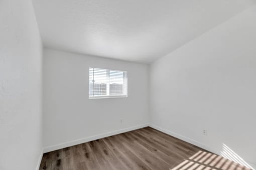 the living room of our studio apartment atrium with wood flooring and a window