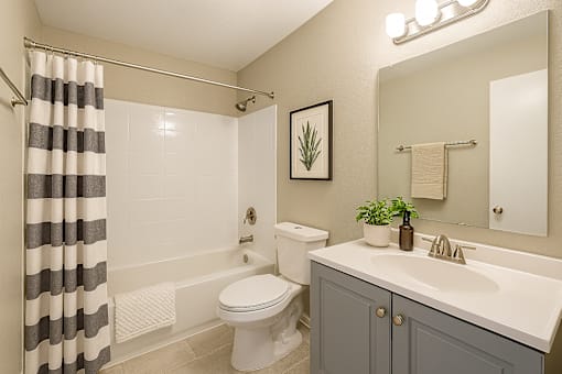 A bathroom with a toilet, sink, and shower.
